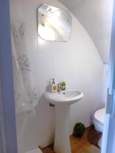 W białej łazience znajduje się umywalka i lustro. w obiekcie T1 Elvas w mieście Elvas