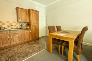 a kitchen with a wooden table and wooden cabinets at Bridge Street Views in Chester