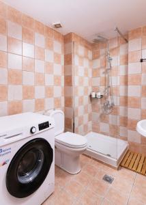 a bathroom with a washing machine and a toilet at Hospitium Crete in Moírai