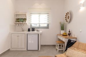 a kitchen with white cabinets and a counter top at Porto Dema Luxury Suites in Schinoussa