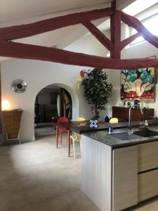 a kitchen with wooden beams and a table in a room at Au petit jasmin in Saint-Puy