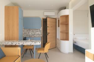 um pequeno quarto com uma cama, uma mesa e cadeiras em Matareva Suites - Ostria Deluxe Suite Studio em Retimno mais 12 fotografias