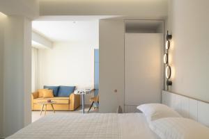 um quarto com uma cama branca e um sofá em Matareva Suites - Ostria Deluxe Suite Studio em Retimno