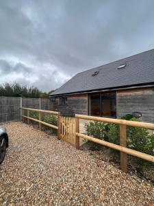 a house with a wooden fence next to a building at The Piggery in Chichester