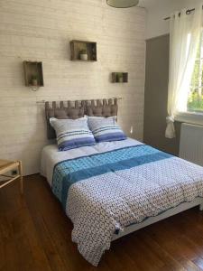 Maison 10 min du circuit des 24h à pied في لو مان: غرفة نوم بسرير من اللون الازرق والابيض