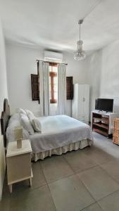 a white bedroom with a large bed and a desk at Casa Kolla in Salta