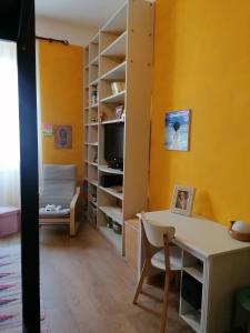 a room with a desk and a chair and a tv at La volpe gialla in Savona