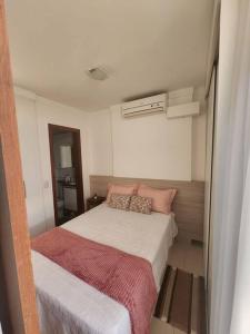 - une petite chambre avec un lit et des oreillers roses dans l'établissement Apartamento Park Sul, à Brasilia