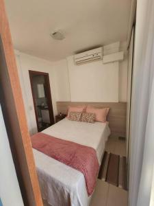 - une petite chambre avec un lit et des oreillers roses dans l'établissement Apartamento Park Sul, à Brasilia