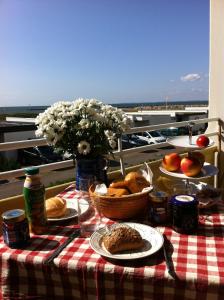 einen Picknicktisch mit Essen und Brot auf einem Balkon in der Unterkunft Burgtiefe Südstrand "Sorglos" in Fehmarn