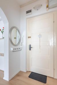 een witte deur met een kruis erop naast een spiegel bij Lisinski apartment with private parking in Zagreb +15 foto's