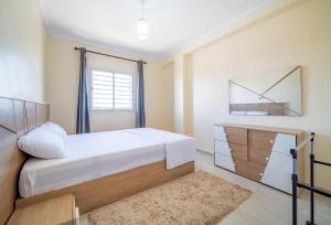 - une chambre avec un lit, une commode et un miroir dans l'établissement Appartement 2 chambre 5min Aéroport, à Marrakech