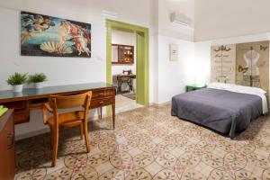 una camera con scrivania e un letto in una stanza di Al 22 Appartamenti a Trapani