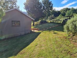 a backyard with a building and a grass yard at Ukutula Resort in Dullstroom