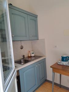 a kitchen with blue cabinets and a sink at Appartamento Monterosso 81 in Monterosso al Mare