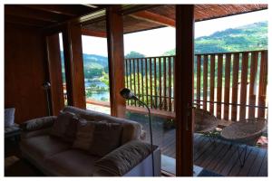 uma sala de estar com um sofá na varanda em Gêres! Caniçada House! em Gerês