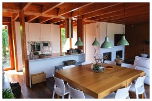 una sala da pranzo e una cucina con tavolo e sedie in legno di Gêres! Caniçada House! a Geres