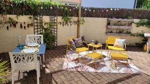 un patio con tavolo, sedie gialle, tavolo e sedie di Le Petit Clos, 3 étoiles a Pont-Saint-Martin