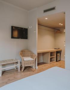 una camera con TV a parete e sedia di Hotel Llane Petit a Cadaqués