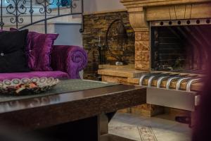 a living room with a purple couch and a fireplace at Dana's Luxury Maisonette in Volos