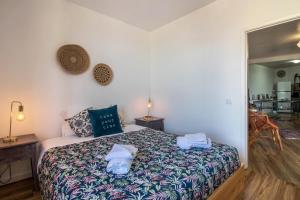 ein Schlafzimmer mit einem Bett mit Handtüchern darauf in der Unterkunft Palmeira House - Fernandes Cottage in Ponta Delgada + 19 Fotos