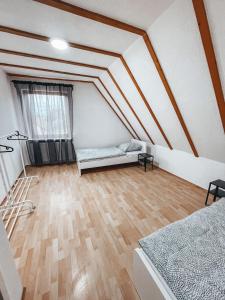 Pokój na poddaszu z łóżkiem i drewnianą podłogą w obiekcie Granny Smith w mieście Neuhofen