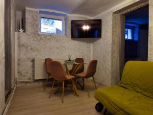 Cette chambre comprend une table, des chaises et un lit. dans l'établissement Signal Suites with Garden & Mountain View, à Braşov
