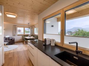 a kitchen and living room with a large window at Hotel Baumgarten & Chalet Baumgarten in Angerberg