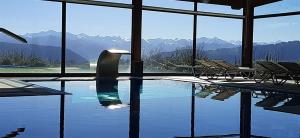 a swimming pool with chairs and a view of mountains at Hosteria de Torazo Nature Hotel & Spa in Torazo