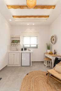 a kitchen with white cabinets and a table at Porto Dema Luxury Suites in Schinoussa
