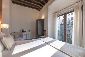 a bedroom with a large bed and a large window at Shine Albayzín in Granada