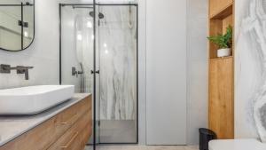 a bathroom with a sink and a shower at Apartamenty Sun & Snow Modern Tower in Gdynia