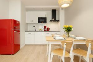 a kitchen with a wooden table and a red refrigerator at Plażowa Park Apartment with Garden by Renters in Międzywodzie