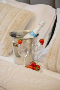 a bucket with a bottle and two glasses on a bed at Plażowa Park Apartment with Garden by Noclegi Renters in Międzywodzie