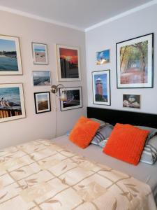 コウォブジェクにあるApartament przy Starówceのベッドルーム1室(オレンジ色の枕と壁の絵付)