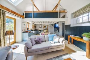 a living room with a couch and a kitchen at Whitechurch Stables 