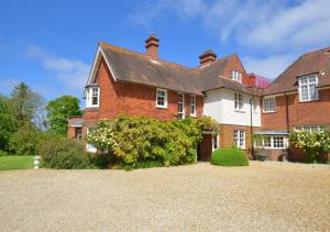 a large red brick house with a driveway at 4 Dormy House in Brancaster