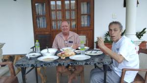 twee mannen aan een tafel eten bij Ceylan Star Guest Inn in Wellawaya