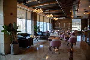 Jeddah Homes Boutique Hotel في عمّان: مطعم بطاولات وكراسي ونوافذ