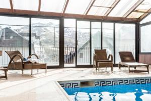 a room with chairs and a swimming pool and windows at Snö Villa de Sallent 3 in Formigal