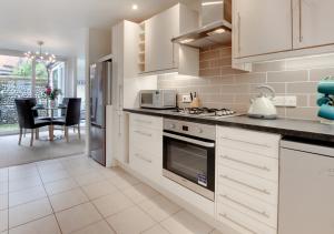 a kitchen with white cabinets and a stove top oven at 7 Sea Mews in Cromer