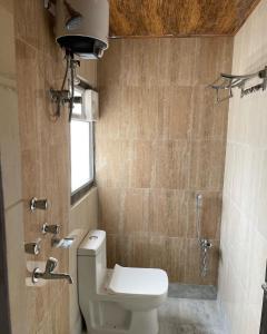 a small bathroom with a toilet and a shower at Atithi Guest House in Siliguri