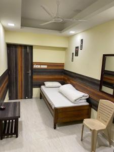 a bedroom with a bed and a table and a chair at Atithi Guest House in Siliguri