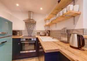 een keuken met een houten aanrecht met een wastafel bij 72 Starboard in Wells next the Sea