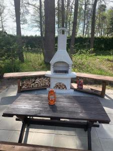 a wooden picnic table with a stove in a park at Chalupa u rybníka in Libín