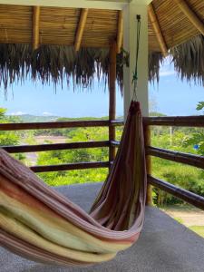 a hammock hanging from a thatch roof at Hosteria Guachapeli in Las Tunas