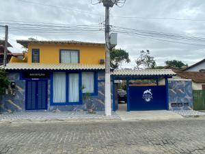 a yellow and blue house with a blue door at Pousada Maresias de Geribá in Búzios