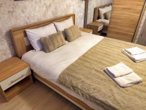 ein Schlafzimmer mit einem großen Bett mit zwei Kissen in der Unterkunft Signal Suites with Garden & Mountain View in Braşov