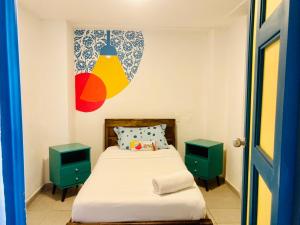 um pequeno quarto com uma cama e duas mesas de cabeceira em Hostal Casa Lantana La Candelaria em Bogotá