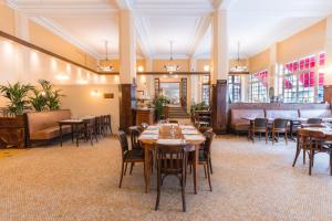 una sala da pranzo con tavoli e sedie in legno di L'Hotel De L'Esperance a Lisieux